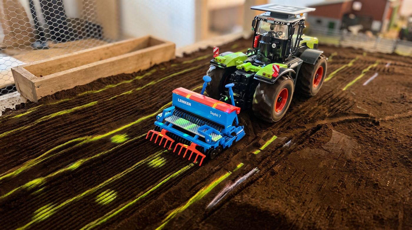 Insel 2: Kartoffeln setzen — hinter dem Traktor leuchten die gesetzten Reihen